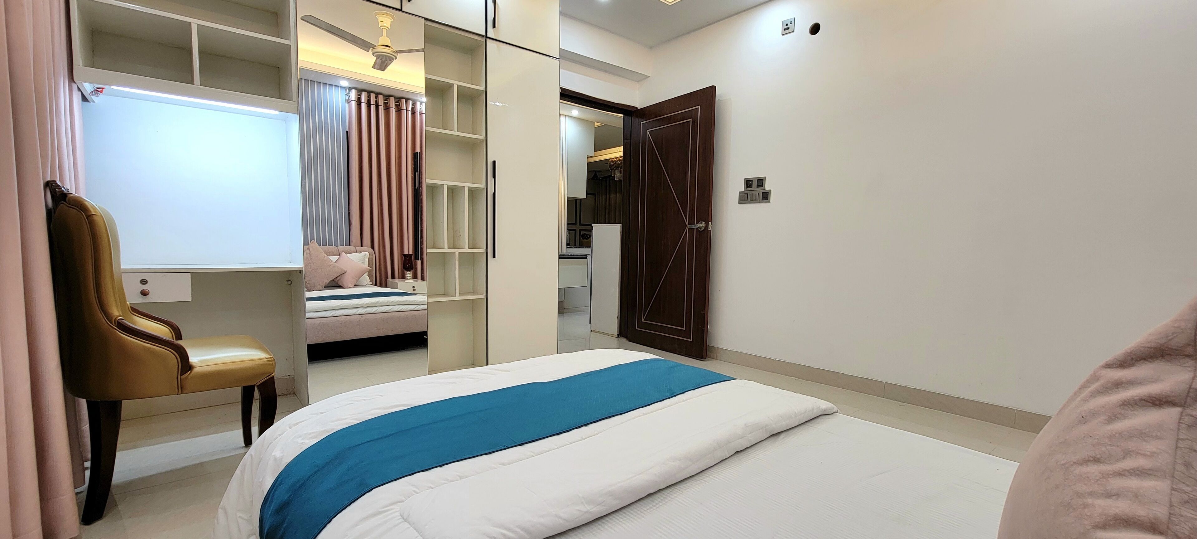 Un dormitorio con cama, una silla, un armario y una puerta.