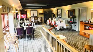 A restaurant with a checkered floor, multiple tables and chairs, and framed pictures on the walls. - Newton Stewart-sleeps 6-pool-parking-pet Friendly (Newton Stewart)