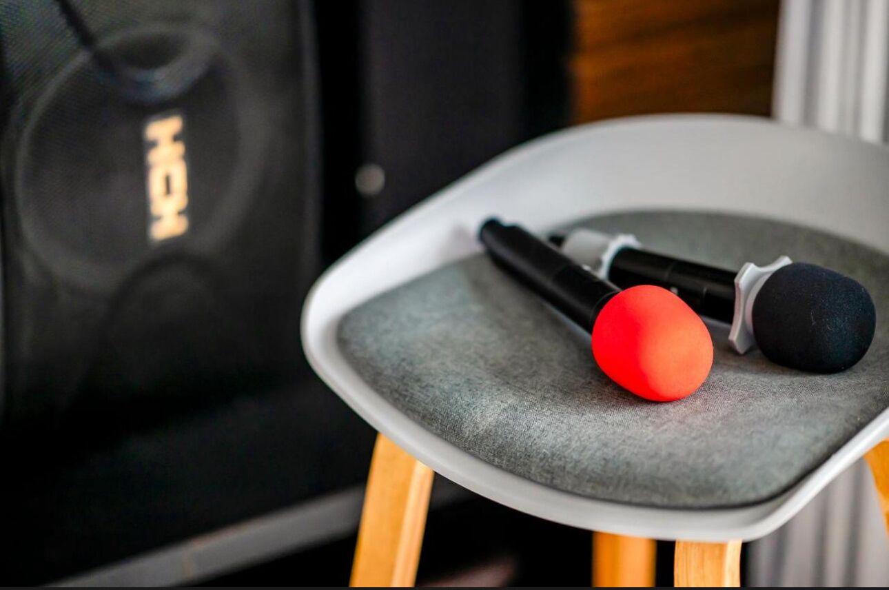 Un micrófono y un objeto rojo sobre una silla.