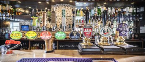 A bar with multiple beer taps and a sign for Tribute Cornish Pale Ale.