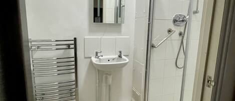 A bathroom with a toilet, sink, and glass-enclosed shower.