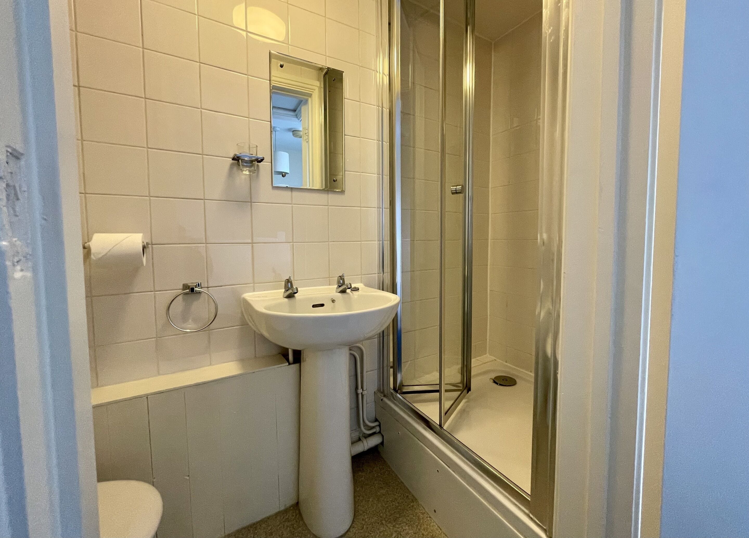 A bathroom with a white sink, toilet, and shower.