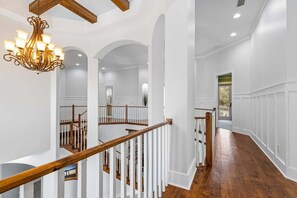 A spacious interior with a wooden staircase, white walls, and a chandelier. - Luxe, Lakefront, Heated Pool/Spa, 5 mins to Beach (Santa Rosa Beach)