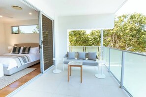 A modern bedroom with a bed, a sofa, and a small table.