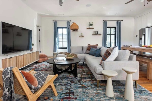 A modern living room with a sofa, coffee table, and a TV.