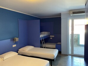 A room with two single beds, a bunk bed, and a sliding glass door leading to an outdoor area. - Hotel Liberty Self Check-in (Bellinzona)