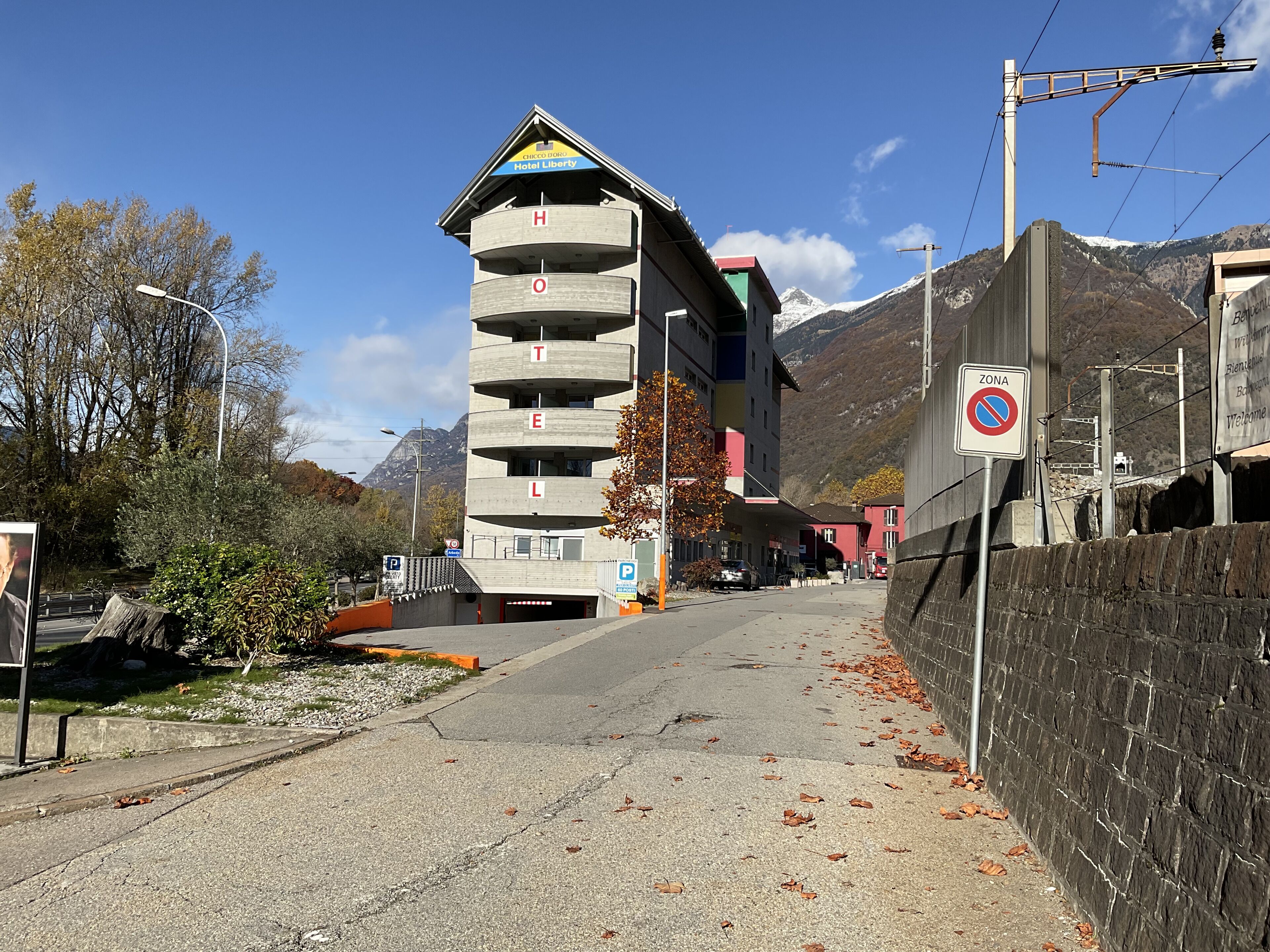 Un hôtel à plusieurs étages, reconnaissable à son grand panneau « Hôtel Liberty », doté d’un parking et situé dans un cadre montagneux.