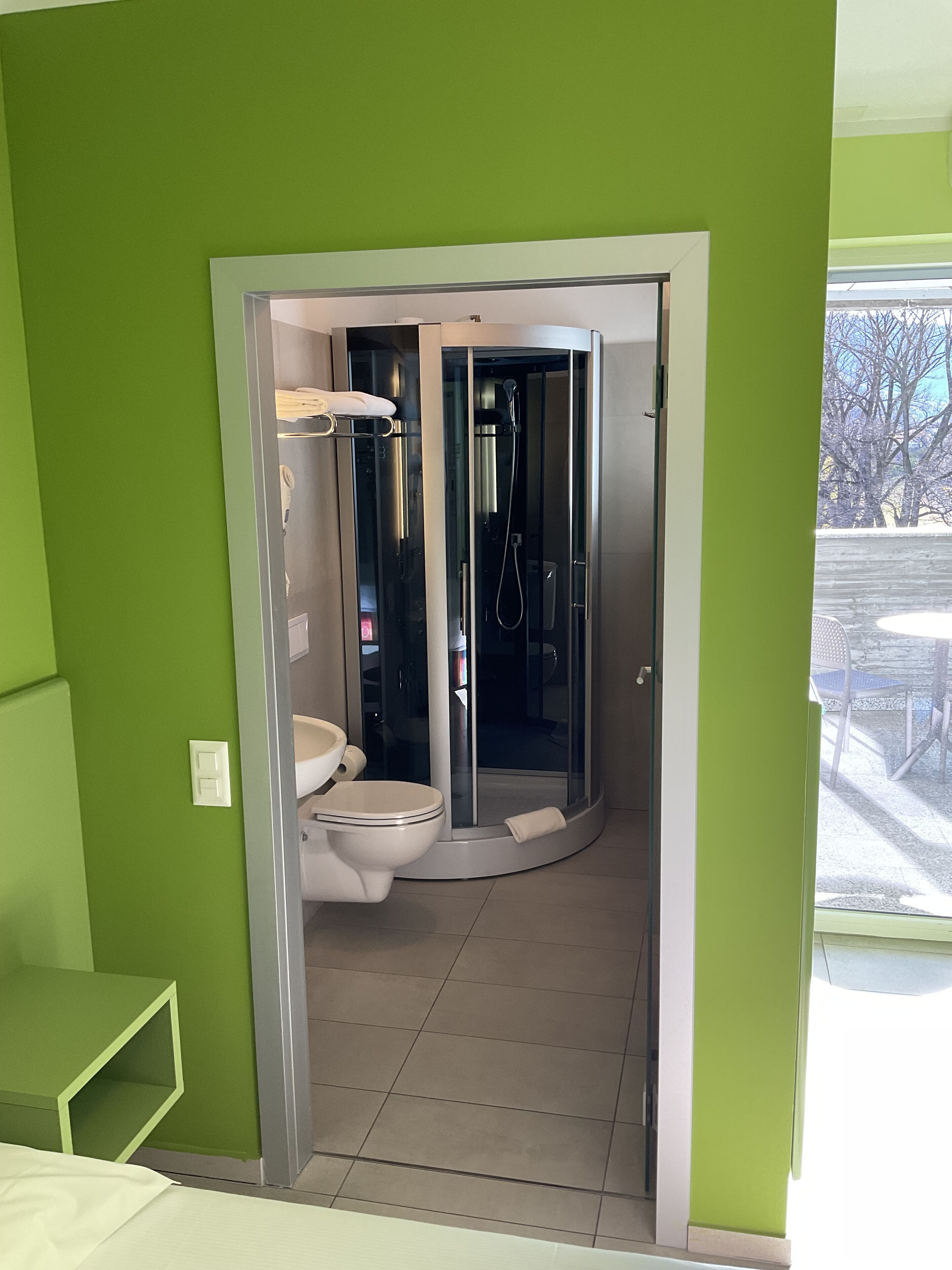 Une salle de bain avec une douche à parois de verre, des toilettes et un lavabo.
