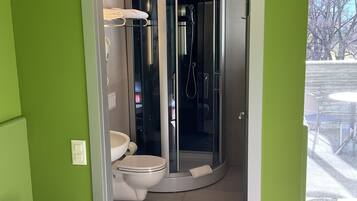 Une salle de bain avec une douche à parois de verre, des toilettes et un lavabo.