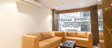 A modern living room with a beige sectional sofa and a glass coffee table.