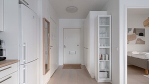 Une cuisine moderne avec des meubles blancs, un four encastré et un four à micro-ondes.