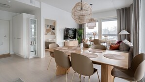 Un espace repas moderne avec une table en bois, six chaises et des suspensions décoratives en fibres tressées.