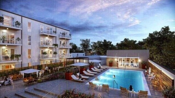 Un hotel con piscina, mobiliario exterior y varios balcones.