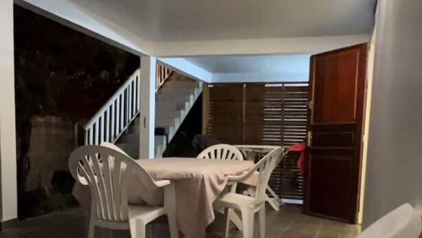 Un espace repas comprenant une table et des chaises, un escalier et une vue sur l’extérieur.
