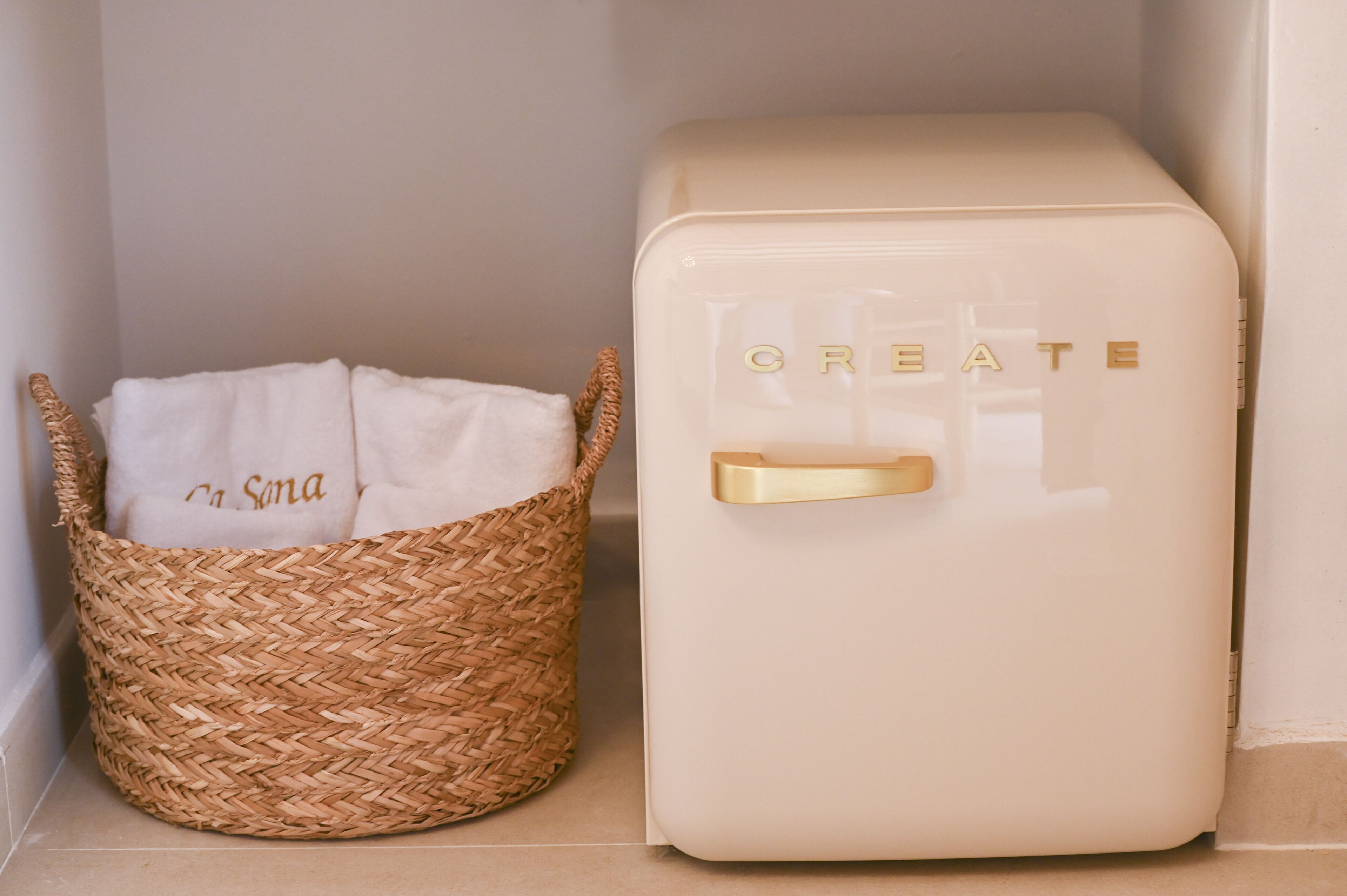 A woven basket with a white cloth labeled "na Sona" and a cream-colored appliance with the word "CREATE" on it.