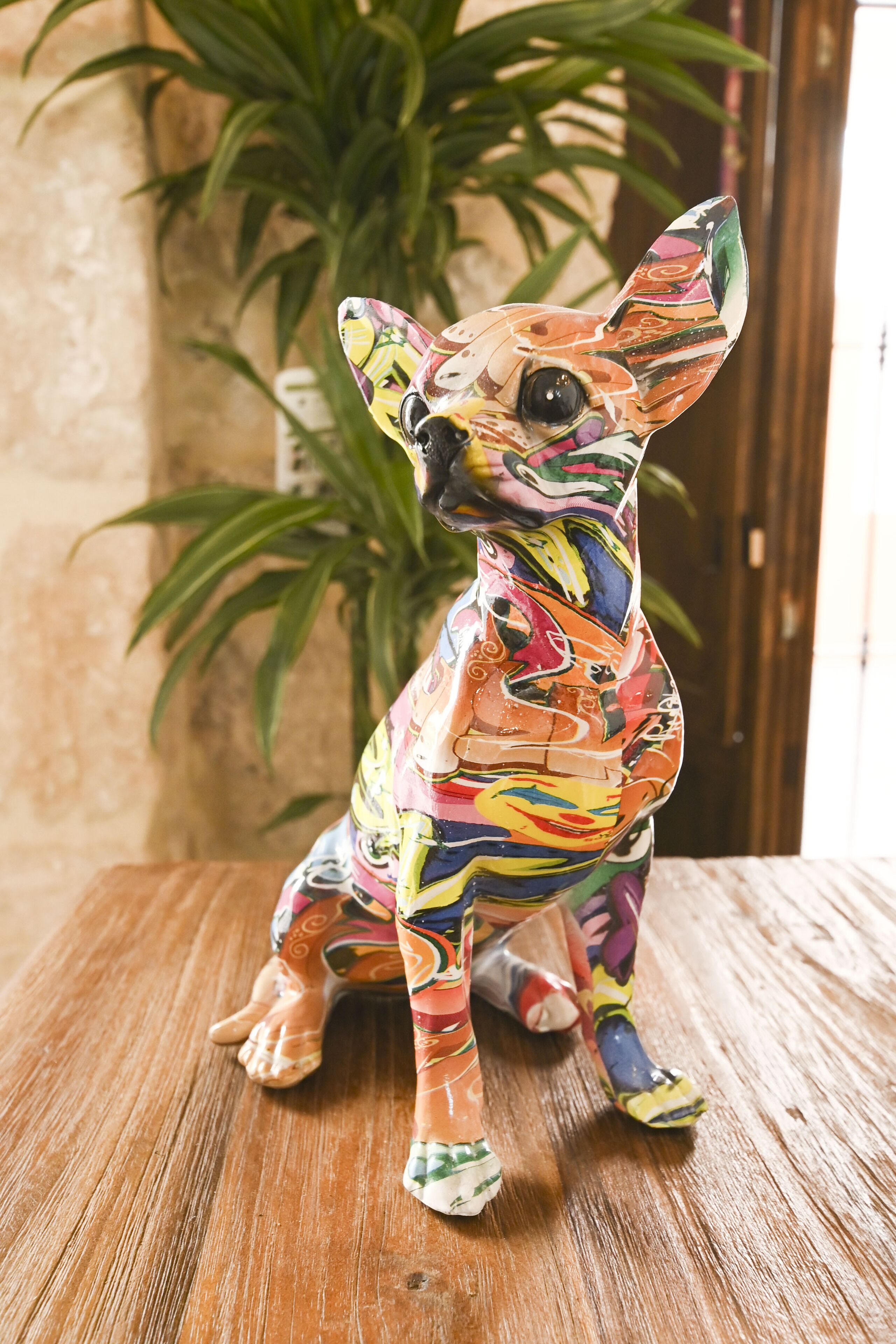 A colorful ceramic dog figurine on a wooden surface.