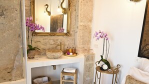 A bathroom with a stone sink, a gold-framed mirror, and purple orchids. - Ca sana Boutique Taulada Moraira (Teulada)