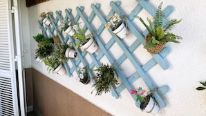 A wall-mounted wooden lattice with various potted plants and flowers. - Villa Conchi (Les Tres Cales)