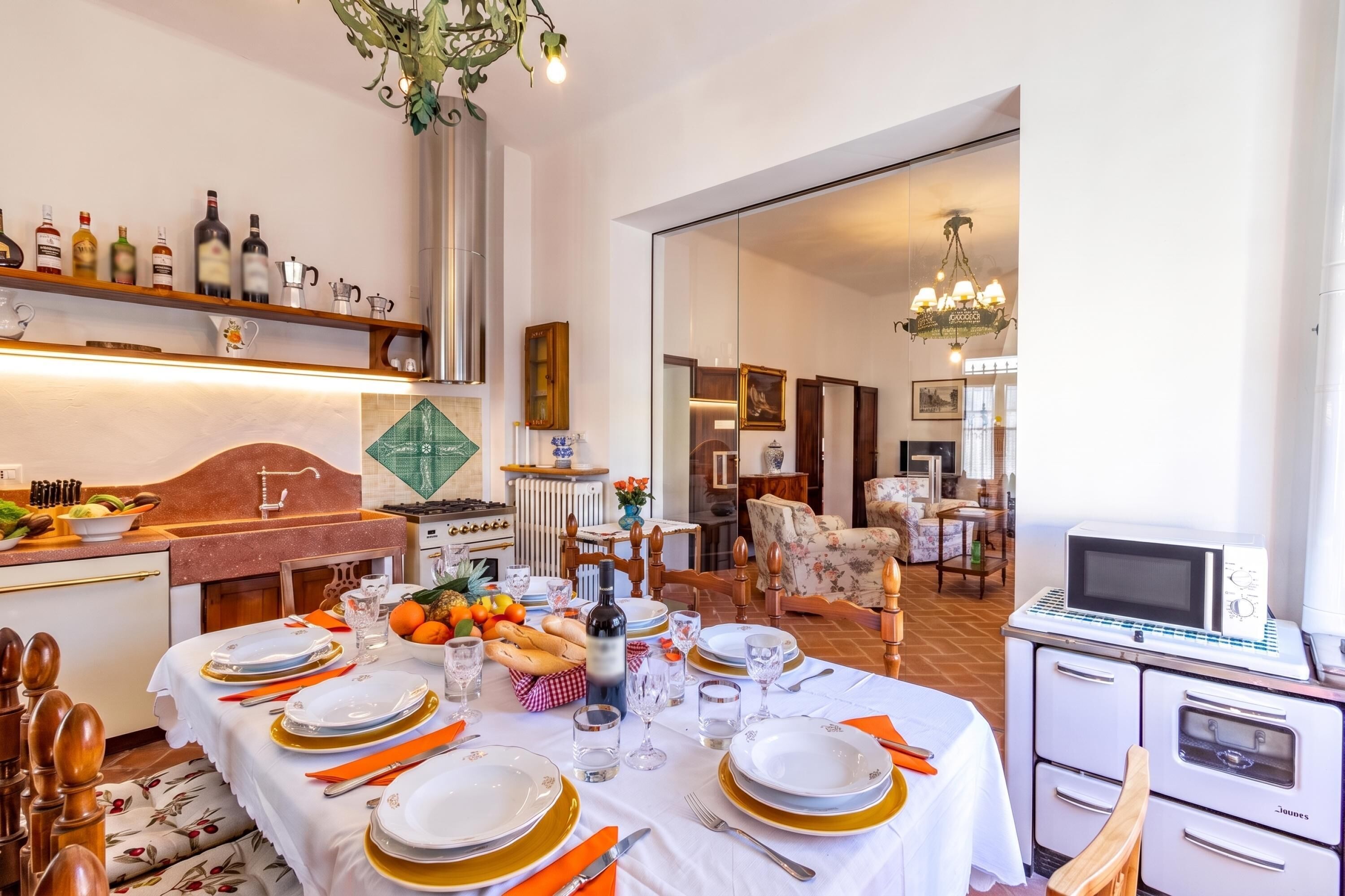 Comedor con una mesa dispuesta para seis personas, electrodomésticos y vista al salón.