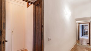 A hallway with a white door, a wooden door frame, and a light switch on the wall. - Chianti Classico Home Panoramic View (Castellina in Chianti)