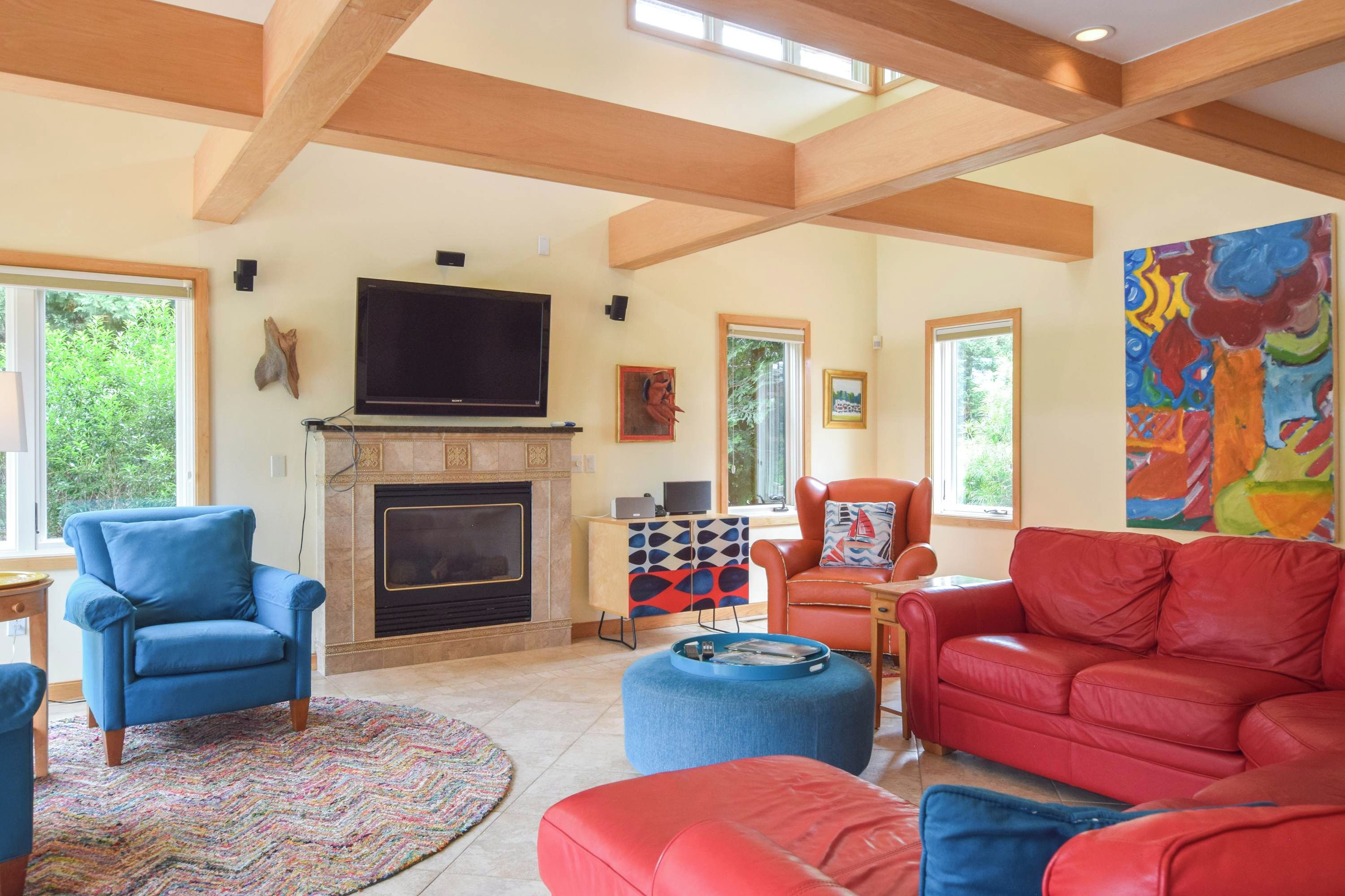 A spacious living room with a fireplace, comfortable seating, and artwork on the walls.
