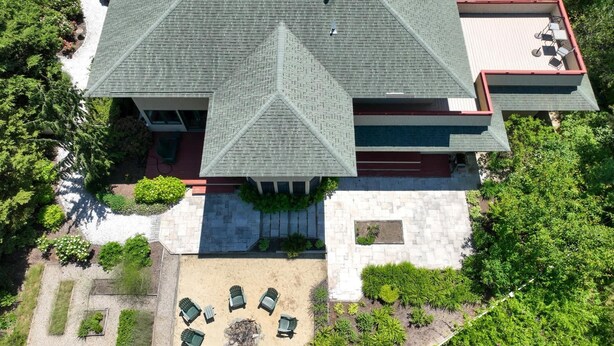 A large building with a symmetrical roof, a courtyard with outdoor seating, and a garden area. - Beautiful backyard, pool, deeded beach rights! (Truro)