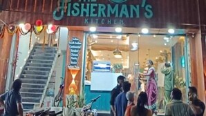 Un edificio de varios pisos con un restaurante llamado "The Fisherman's Kitchen" en la planta baja.