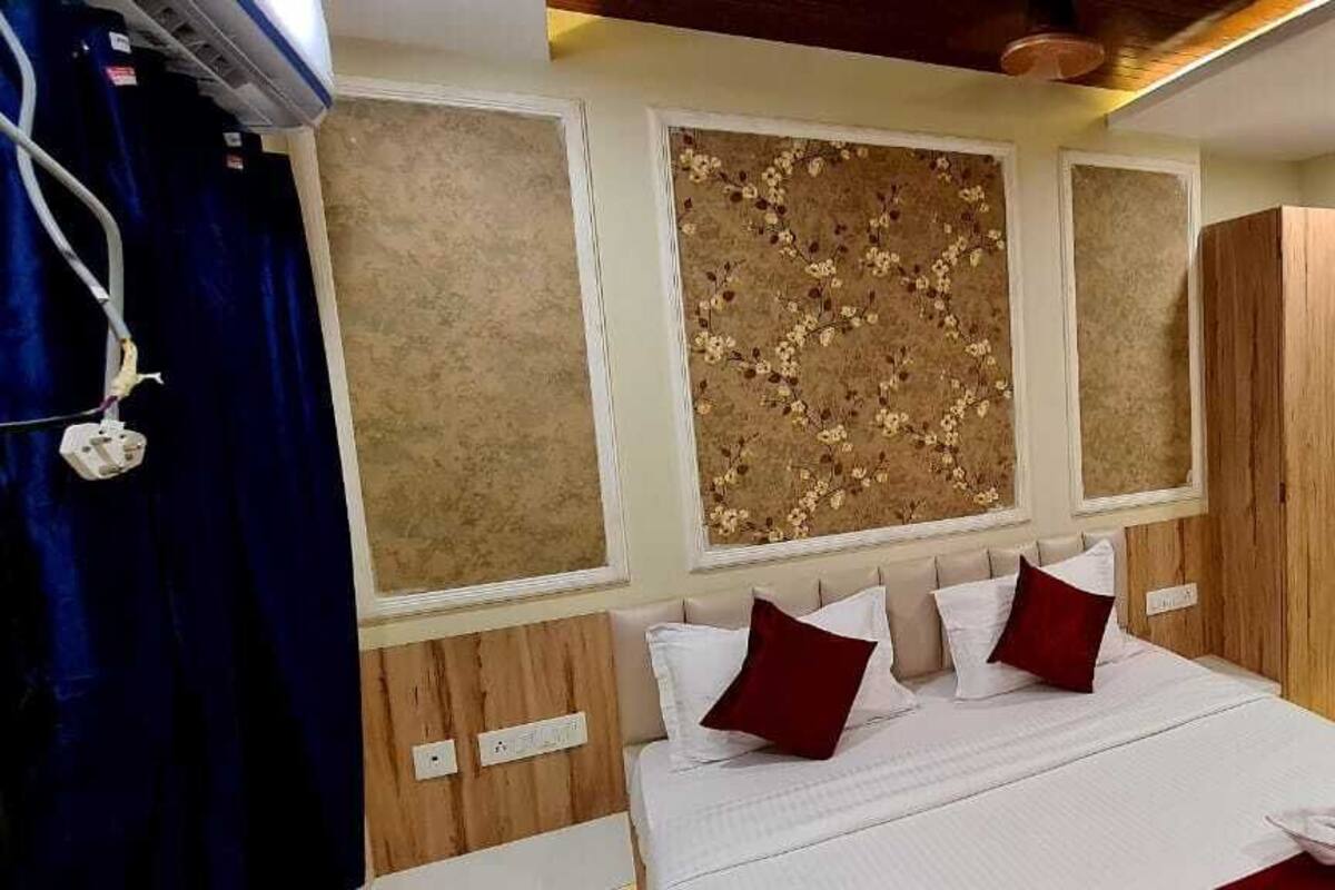A bedroom with a bed, wooden wardrobe, and a door.