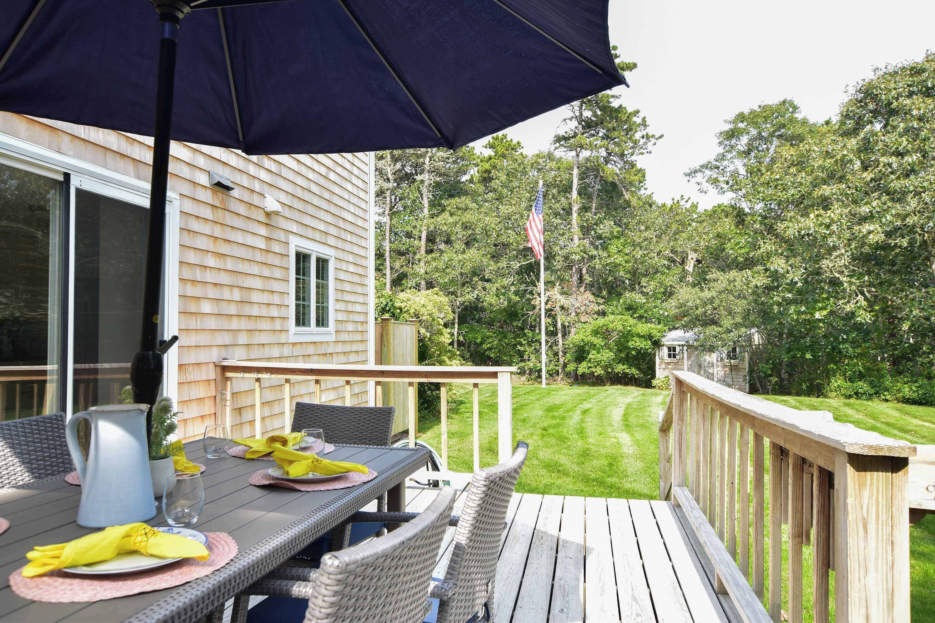 A deck with outdoor furniture, a table, and a grill.