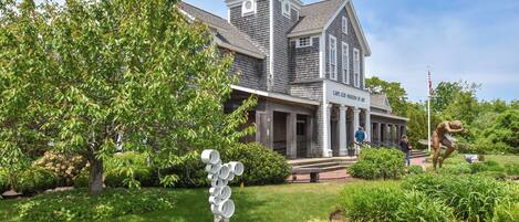 A historic building with a tower and a sign reading 'Cape Cod Museum of Art'.