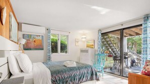 A bedroom with a bed, a desk, a chair, a window, and a balcony with a staircase. - Lake House in Centerville with Private Water Access! (Barnstable)