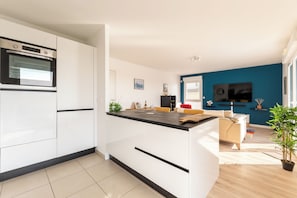 Penthouse có tầm nhìn toàn cảnh, 3 phòng ngủ, trang thiết bị hỗ trợ người có khó khăn khi di chuyển | Khu phòng khách | Smart TV 55-inch có truyền hình cáp, máy chơi game, Netflix 