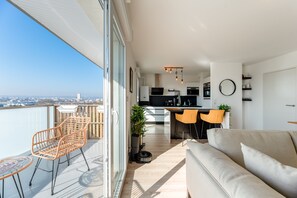 A modern apartment with a balcony, a kitchen, and a living area. - Rouen Seine View Apartment – Close to Center with Parking Included (Rouen)