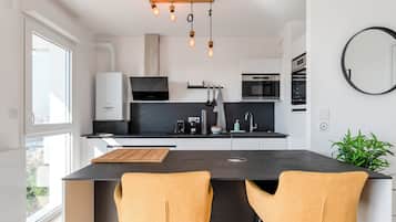 Panorama penthouse | Privékeuken | Een koelkast met diepvriezer, een microgolfoven, een oven, een kookplaat