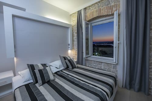 Deluxe kamer, 1 twee- of 2 eenpersoonsbedden, gedeeltelijk uitzicht op zee | Luxe beddengoed, bedden met traagschuimmatrassen, een minibar