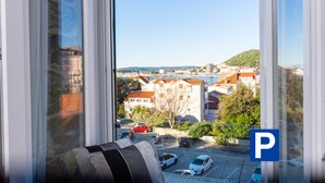 A view from a window with a parking sign, buildings, and a hill in the distance. - A Heritage Hotel Split (Split)