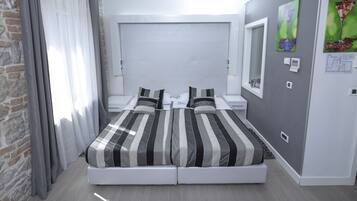 Un dormitorio moderno con una cama grande, una mesita de noche y cabecera integrada.
