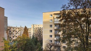 A residential building with multiple balconies, surrounded by trees and other buildings. - Apartment in the center of Warsaw | Balcony and Workspace (Warszawa)