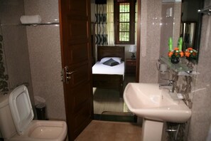 Cozy retreat with a single bed, bedside table, and mirror.