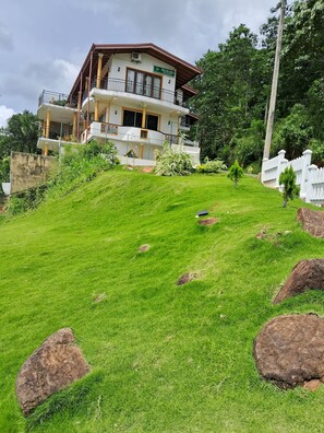Stunning residence surrounded by lush greenery and a well-manicured lawn.