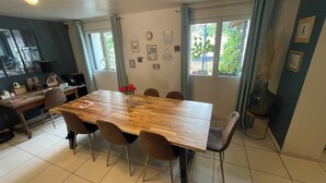 Ein Essbereich mit einem Holztisch, sechs Stühlen und einer Vase mit roten Blumen.