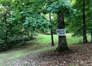 Un panneau indiquant un sentier de randonnée au cœur d’une zone boisée.