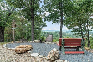 A park bench, a wooden staircase, and a signpost surrounded by trees. - Secluded Eureka Cabin | King | Mountain Spa Tub (Eureka Springs)