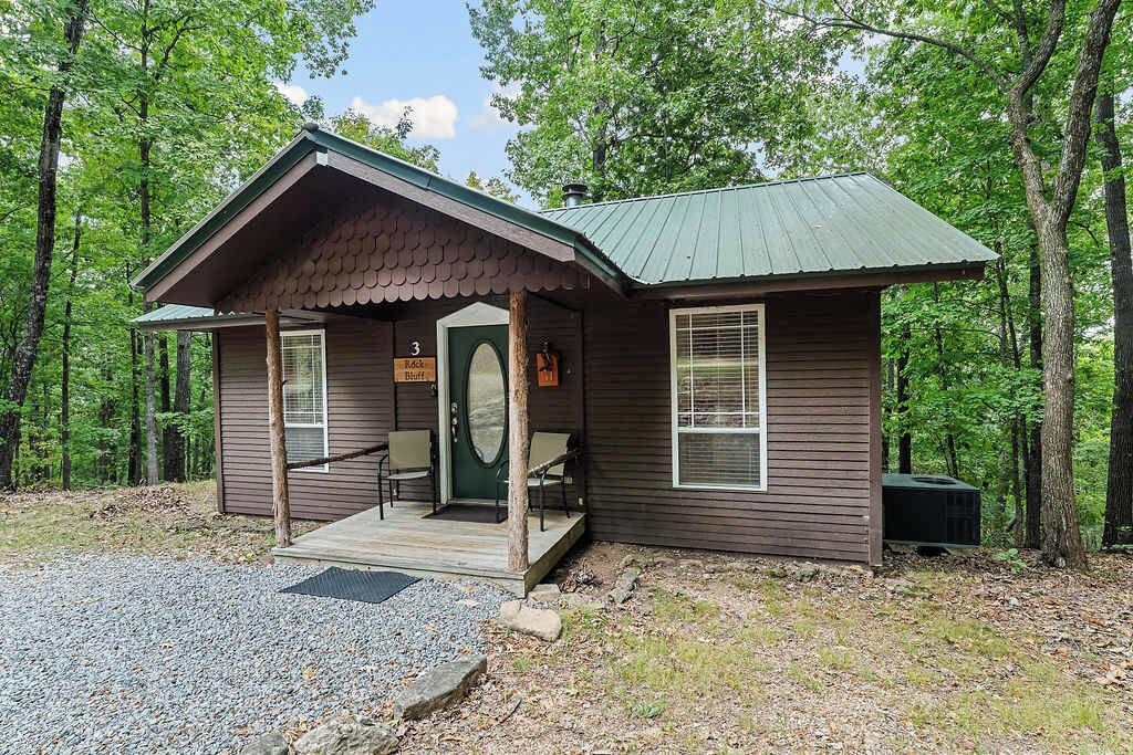 A cabin with a porch, a door, and a window.
