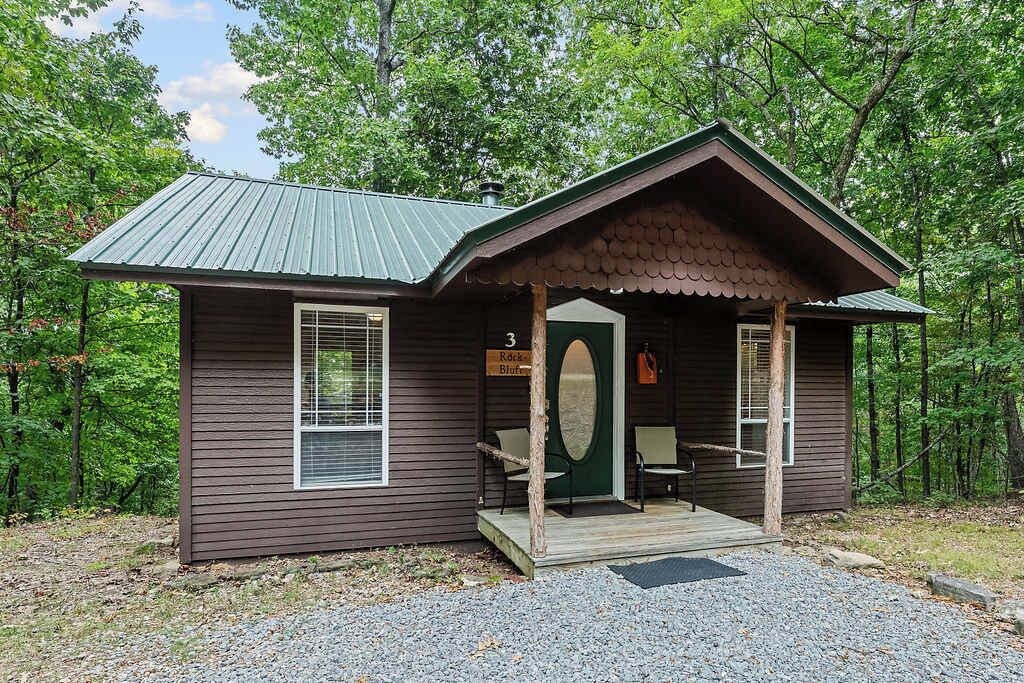 A small cabin with a porch, a door, and a window.