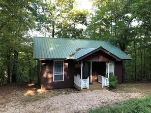 A small cabin with a porch, surrounded by trees. - Secluded Eureka Cabin | King | Mountain Spa Tub (Eureka Springs)
