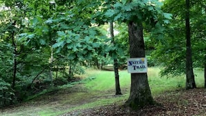 A sign for a nature trail in a wooded area.