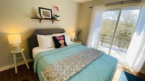 A bedroom with a bed, a nightstand, a window with curtains, and a view of the outdoors. - Near Marina, Kitchen, FAST WiFi, Hiking near by! (Holiday Island)