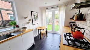 Eine moderne Küche mit Gasherd, einem Fenster und Blick auf den Garten.