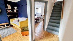 Ein moderner Wohnraum mit einer Couch, einem Esstisch und einer Treppe.